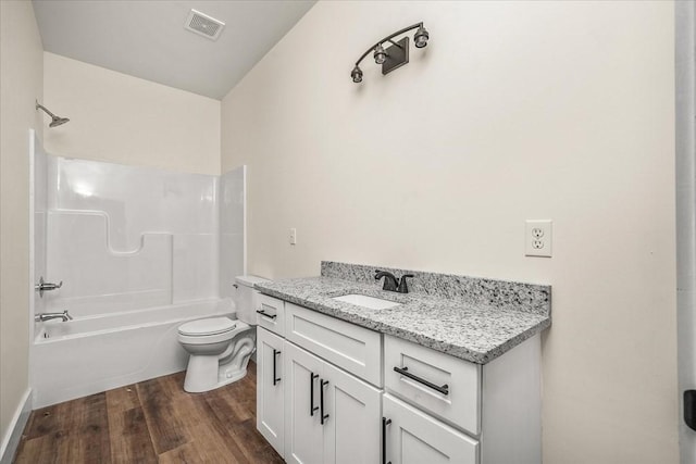 full bathroom featuring vanity, toilet,  shower combination, and hardwood / wood-style floors