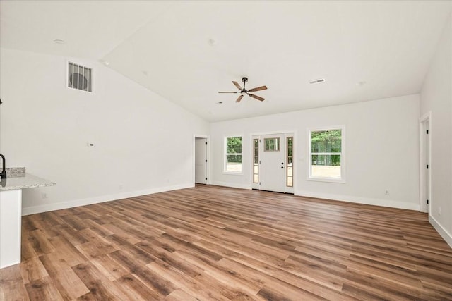 unfurnished living room featuring lofted ceiling, hardwood / wood-style floors, and ceiling fan