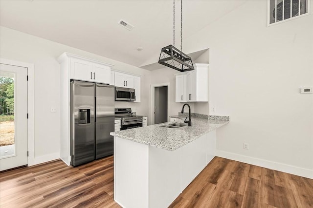 kitchen featuring sink, stainless steel appliances, hanging light fixtures, and white cabinets