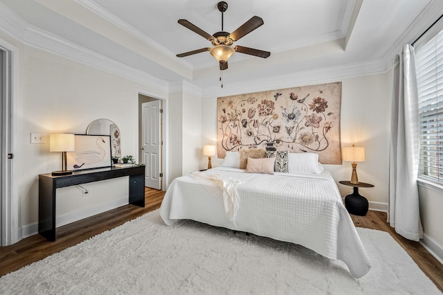 bedroom featuring crown molding, ceiling fan, dark hardwood / wood-style flooring, and a raised ceiling