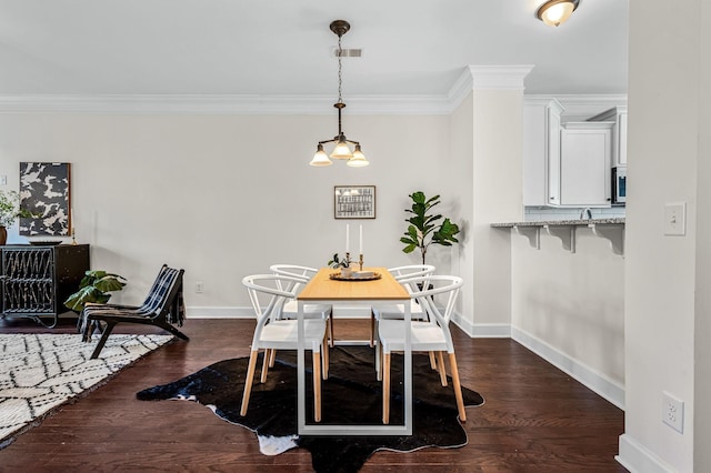 dining area with crown molding and dark wood-type flooring