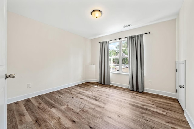 unfurnished room with hardwood / wood-style flooring