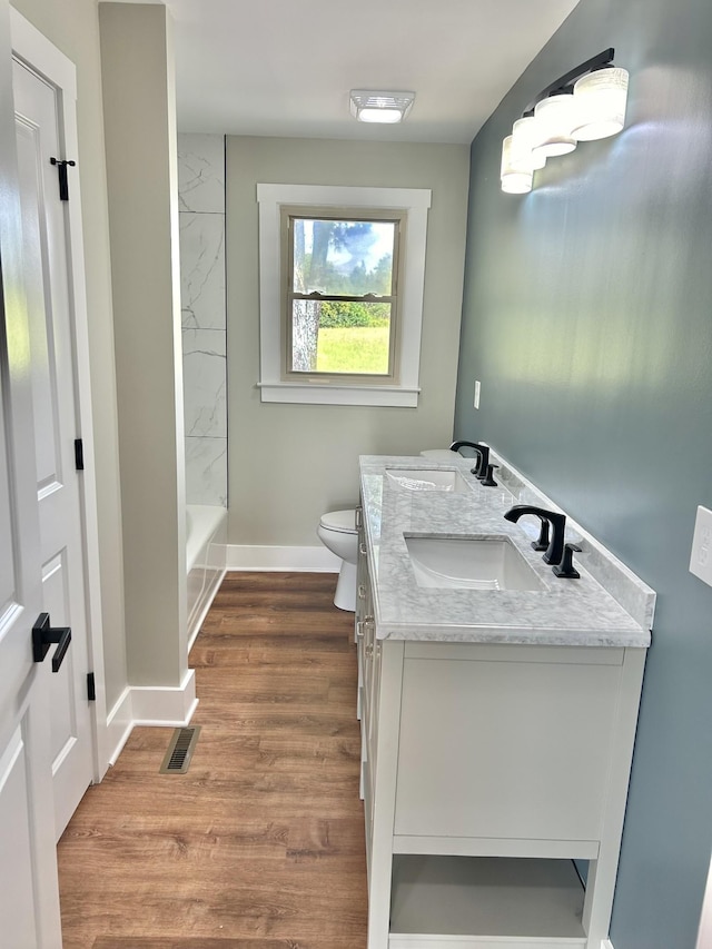 full bathroom with vanity, hardwood / wood-style floors, toilet, and washtub / shower combination