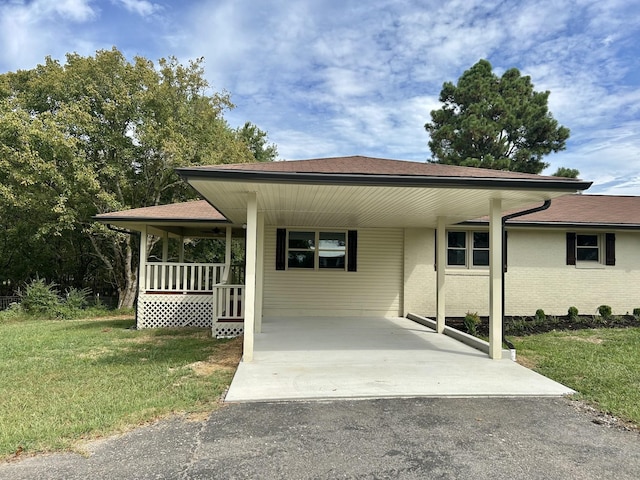 view of front of home featuring a carport, a porch, and a front yard