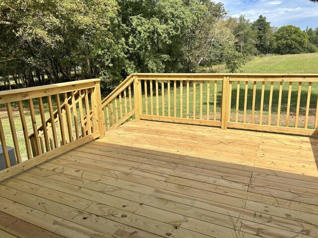 wooden terrace with a yard and central AC unit