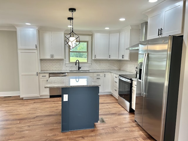 kitchen with sink, white cabinetry, decorative light fixtures, a kitchen island, and stainless steel appliances