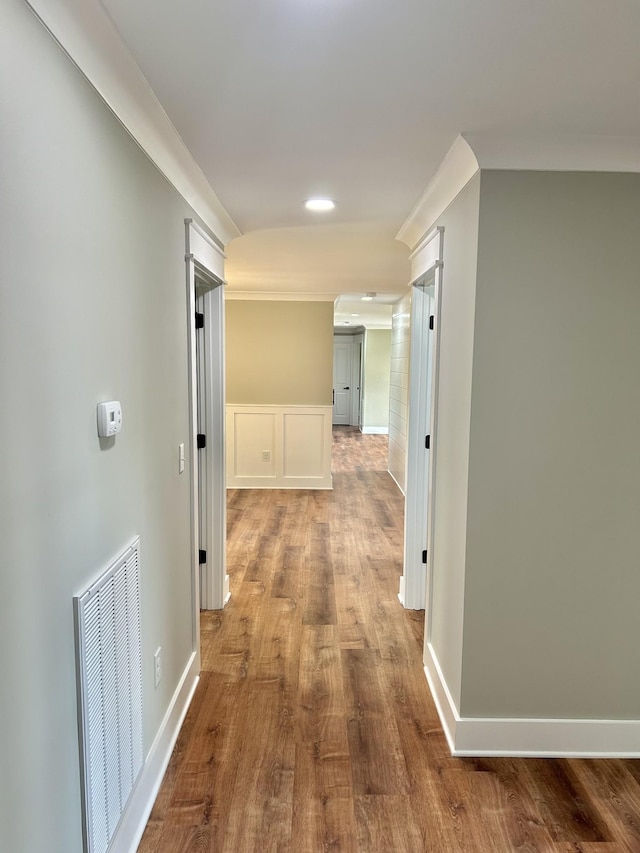 hallway featuring hardwood / wood-style floors and crown molding