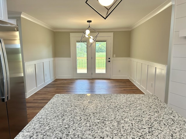 unfurnished dining area with ornamental molding and dark hardwood / wood-style floors