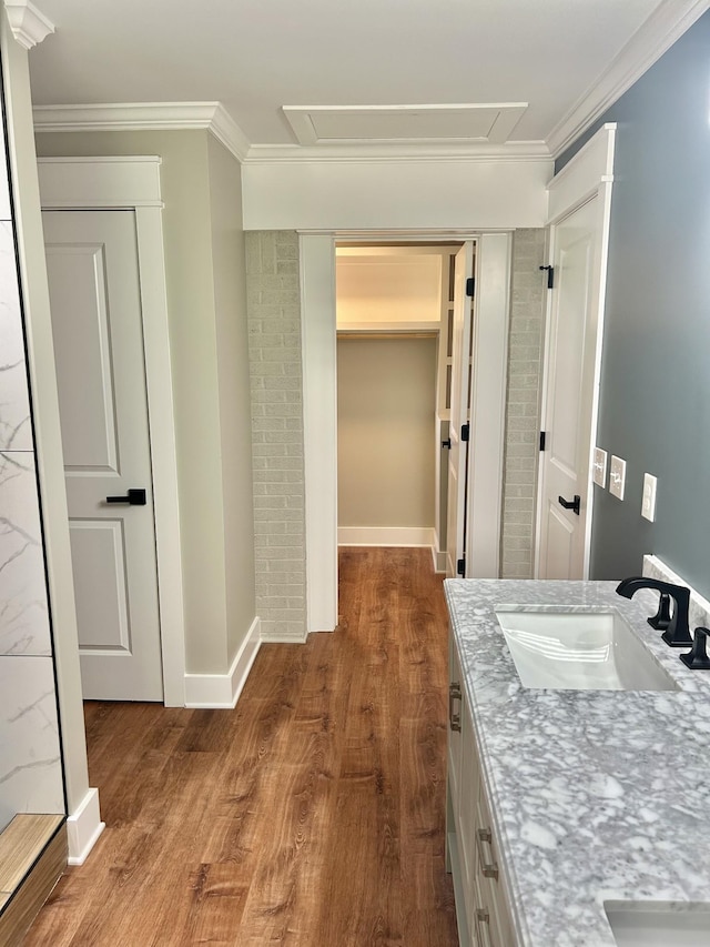 bathroom featuring vanity, wood-type flooring, and ornamental molding