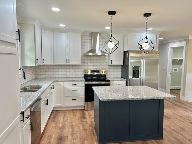 kitchen featuring hanging light fixtures, stainless steel appliances, a center island, white cabinets, and wall chimney exhaust hood