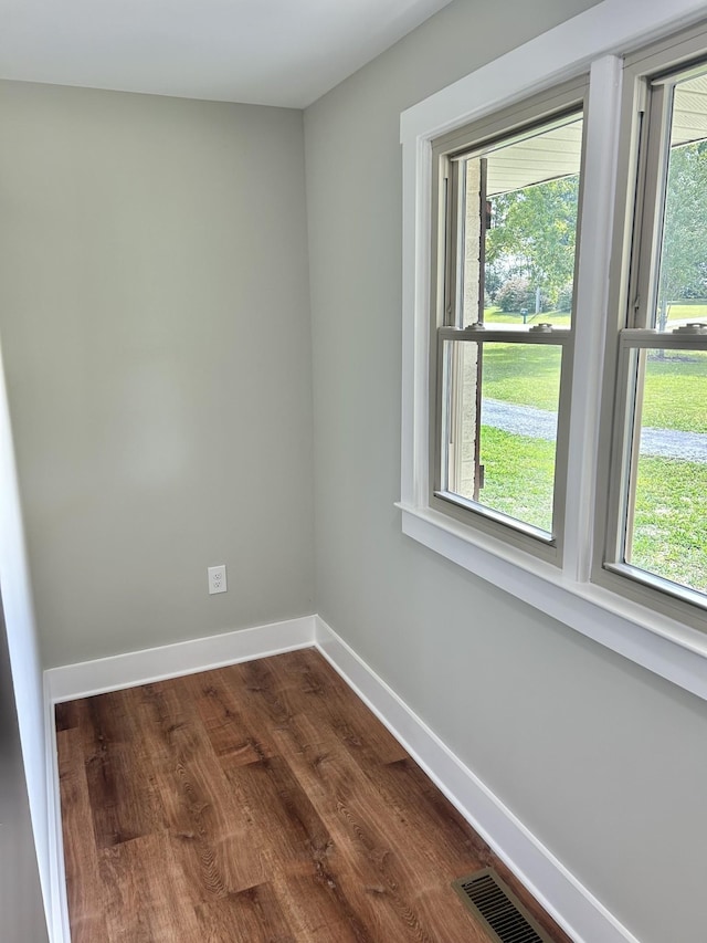 unfurnished room with plenty of natural light and dark hardwood / wood-style floors