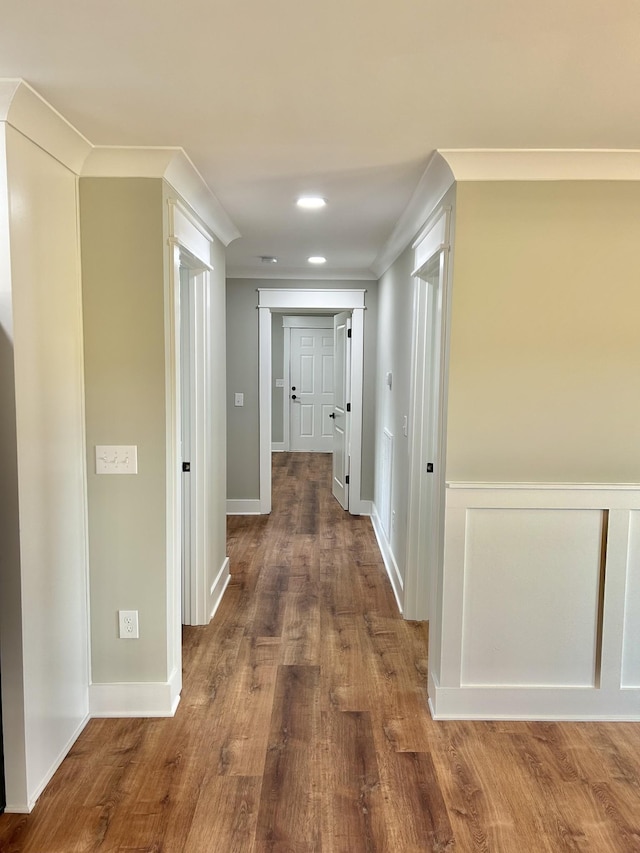 corridor with hardwood / wood-style floors and crown molding