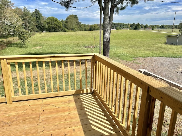 wooden deck with a rural view and a yard