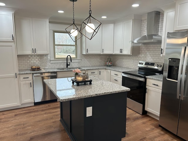 kitchen with wall chimney exhaust hood, sink, a center island, appliances with stainless steel finishes, and white cabinets