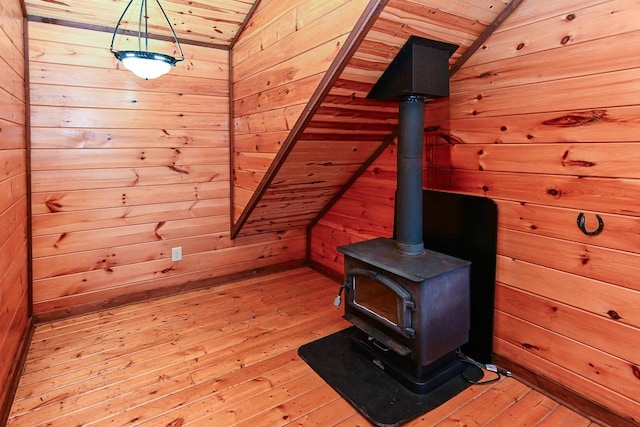 room details featuring wood ceiling, wooden walls, hardwood / wood-style floors, and a wood stove