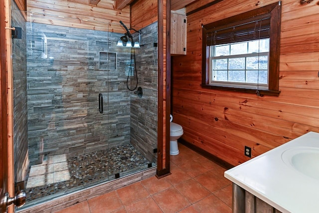 bathroom featuring wood walls, tile patterned flooring, vanity, an enclosed shower, and toilet