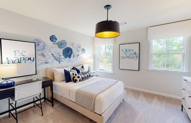 bedroom featuring multiple windows and light colored carpet