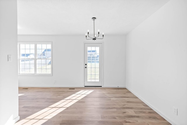 interior space with an inviting chandelier and light hardwood / wood-style floors