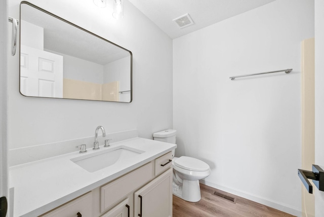 bathroom featuring vanity, hardwood / wood-style flooring, and toilet