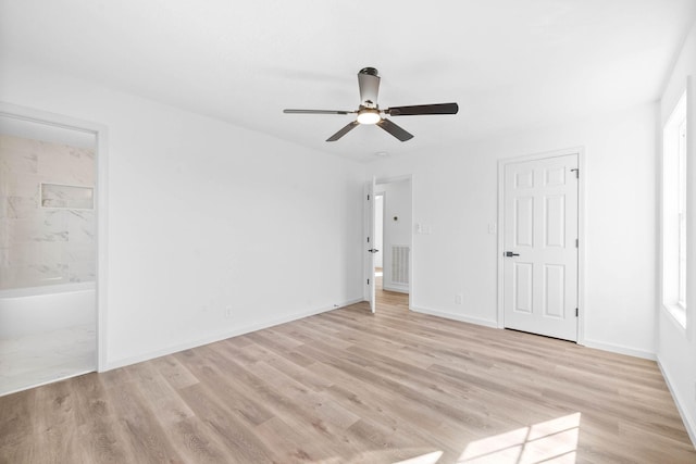 unfurnished bedroom featuring ensuite bath, light hardwood / wood-style flooring, and ceiling fan