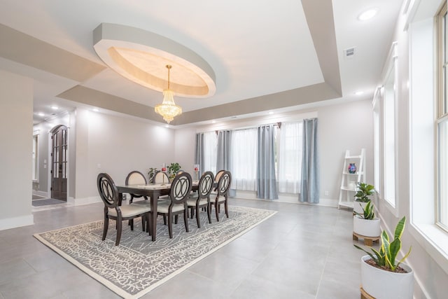 dining area with a chandelier and a tray ceiling