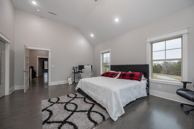 bedroom with dark wood-type flooring and high vaulted ceiling