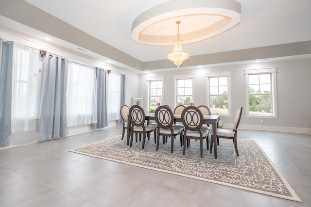 dining area featuring an inviting chandelier and a tray ceiling