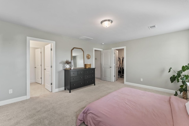 carpeted bedroom with a walk in closet and a closet