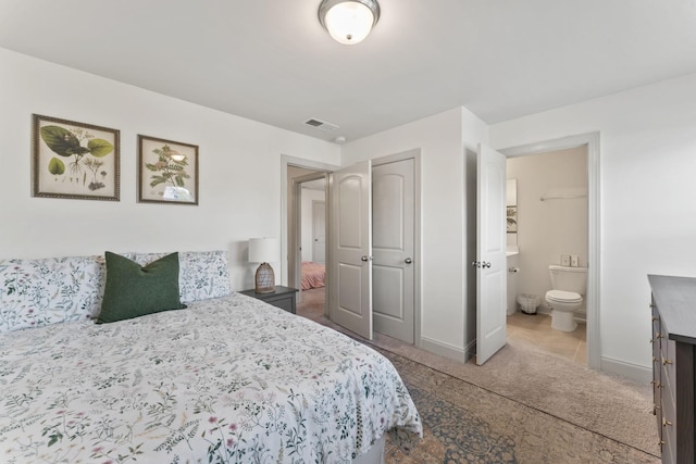 bedroom featuring connected bathroom and light tile patterned flooring