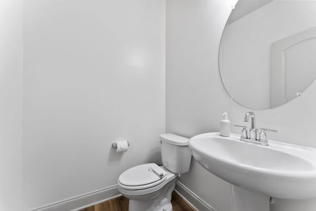 bathroom with wood-type flooring, toilet, and sink