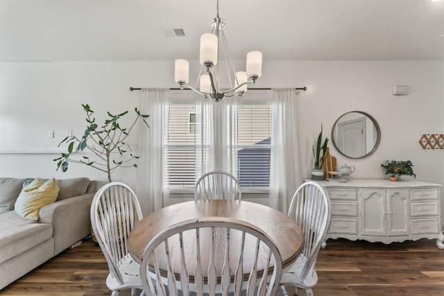 dining area featuring dark hardwood / wood-style flooring and a notable chandelier