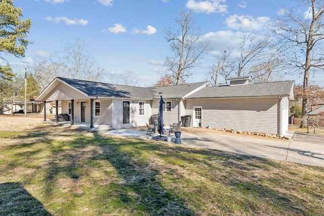 back of house with a patio and a lawn