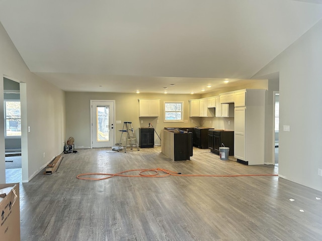 unfurnished living room with vaulted ceiling and light hardwood / wood-style floors