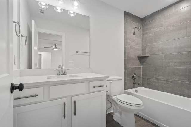 full bathroom with ceiling fan, tiled shower / bath combo, vanity, wood-type flooring, and toilet