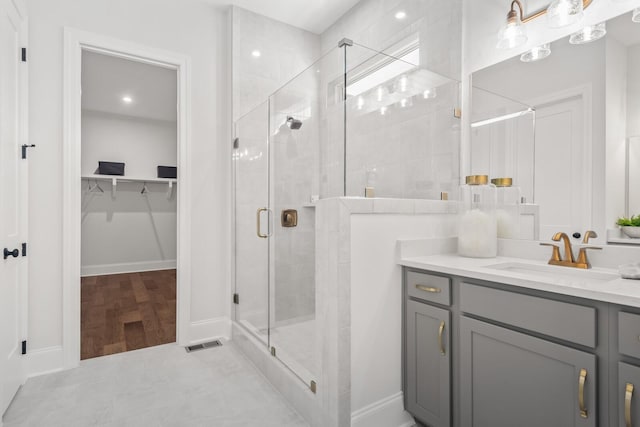 bathroom with vanity and a shower with door