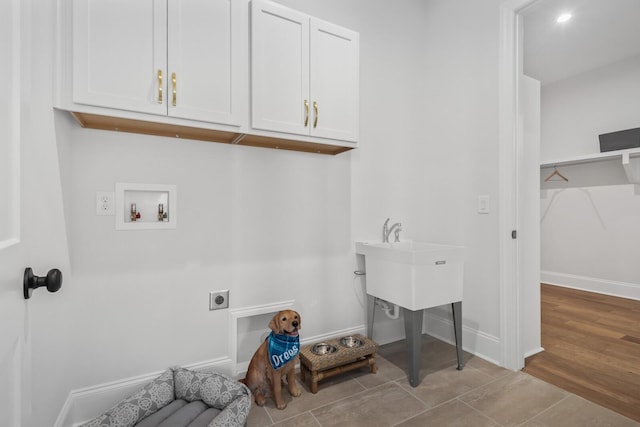 washroom with cabinets, hookup for a washing machine, light hardwood / wood-style flooring, and electric dryer hookup