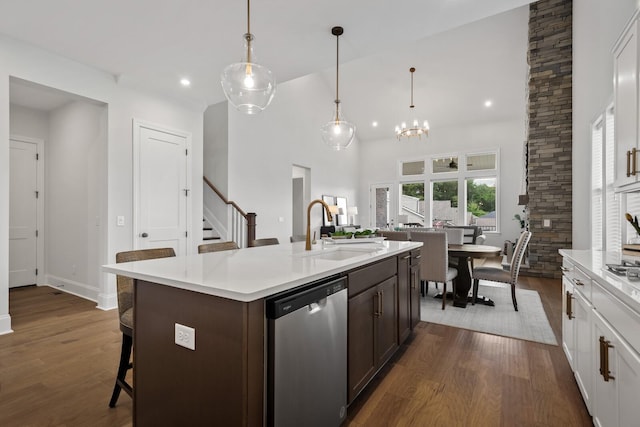 kitchen featuring pendant lighting, sink, stainless steel dishwasher, and white cabinets