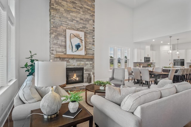 living room with a high ceiling and a stone fireplace