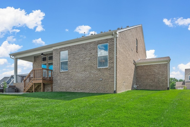 rear view of house featuring ceiling fan and a lawn