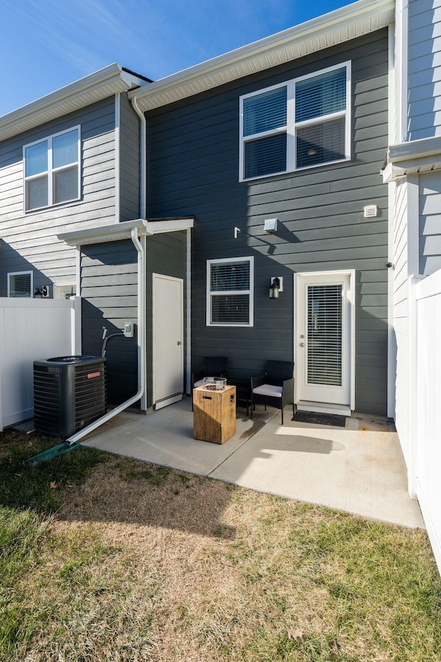 back of property featuring central AC unit, a patio area, and a lawn