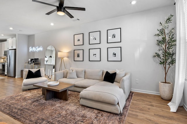 living room with ceiling fan and light hardwood / wood-style floors