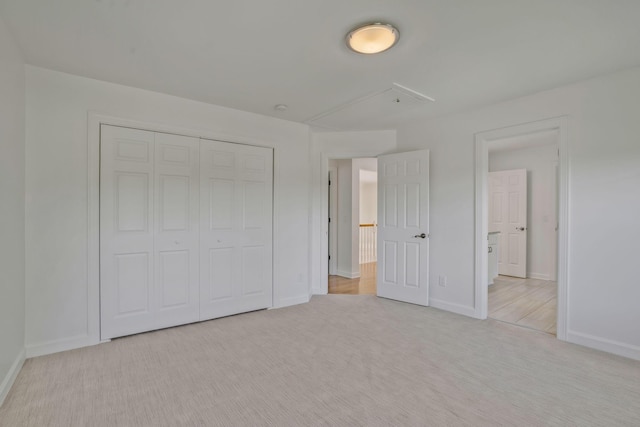 unfurnished bedroom featuring light carpet and a closet