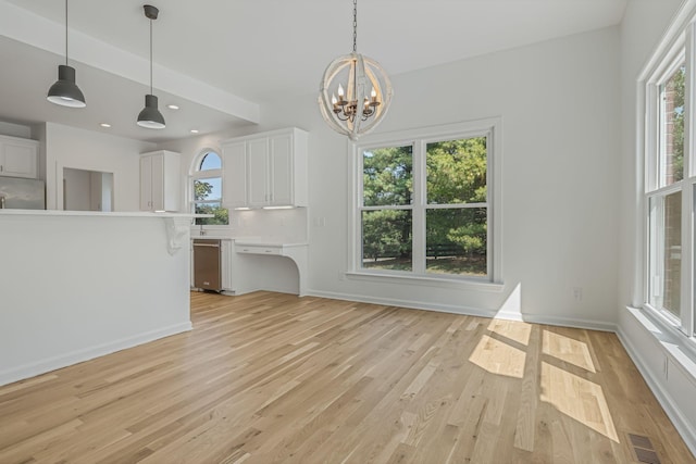 interior space with white cabinetry, plenty of natural light, and decorative light fixtures