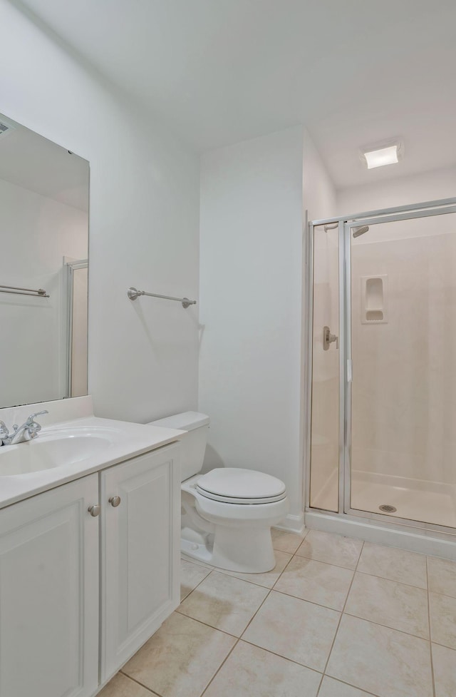 bathroom with tile patterned floors, toilet, a shower with shower door, and vanity