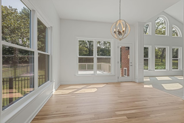 unfurnished sunroom featuring a wealth of natural light and a chandelier