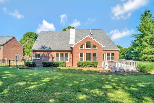 rear view of property featuring a deck and a lawn