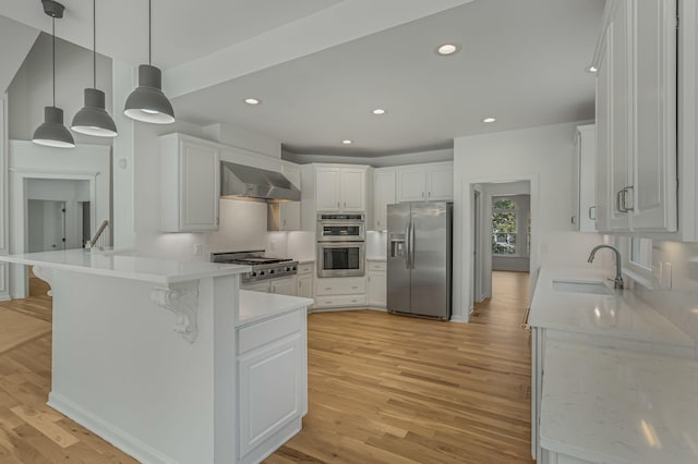 kitchen featuring wall chimney exhaust hood, appliances with stainless steel finishes, and white cabinets