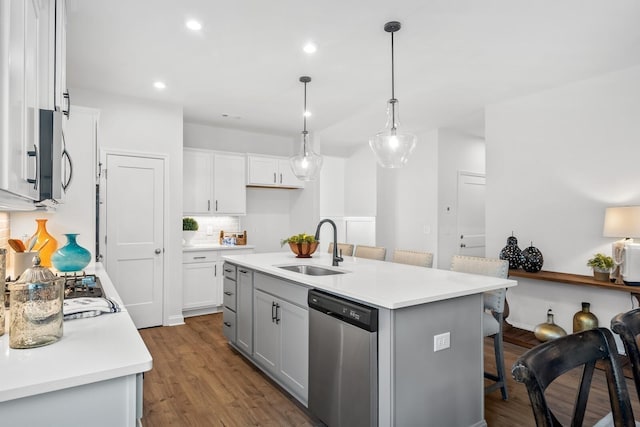 kitchen featuring tasteful backsplash, sink, hanging light fixtures, a kitchen island with sink, and stainless steel appliances