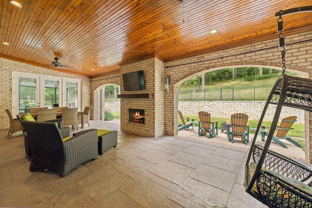 view of patio / terrace with an outdoor brick fireplace and ceiling fan