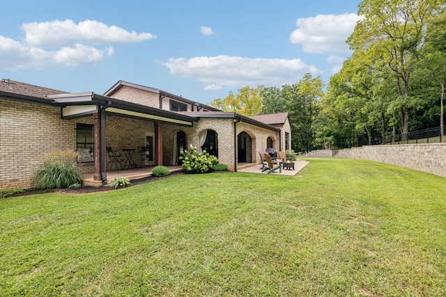 rear view of house featuring a yard and a patio area